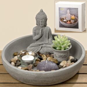 Zenová zahrada Buddha v misce s kameny a svíčkou